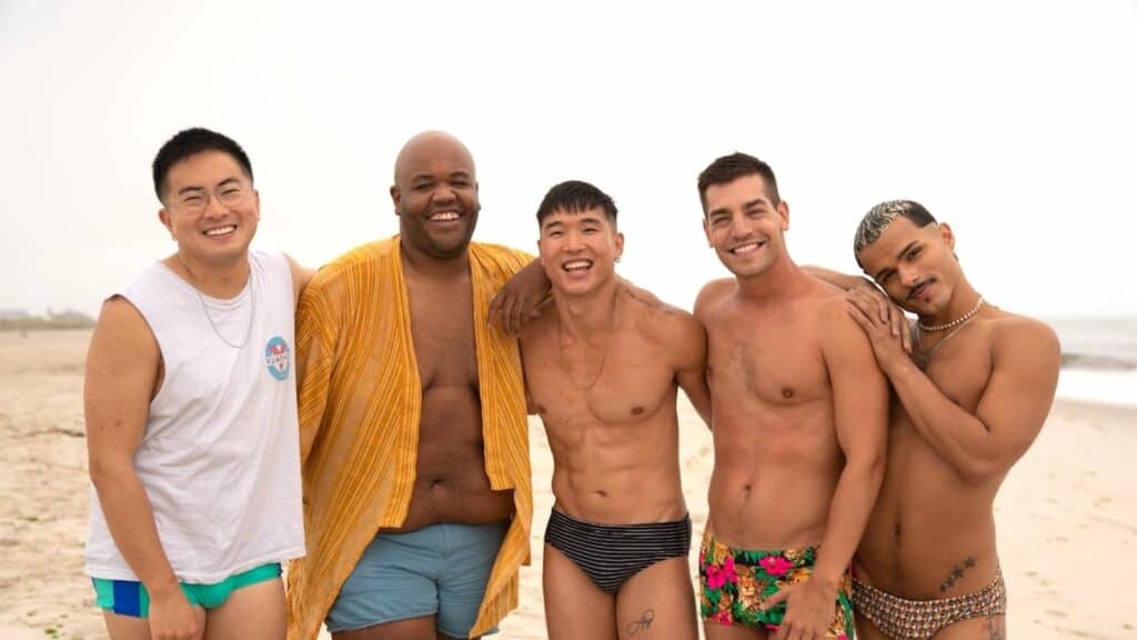 Cast of Fire Island standing on the beach on Fire Island, featured in top LGBTQ+ travel destination movies.